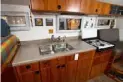  ??  ?? The galley has a Magic Chef three-burner propane stove, two sinks and overhead storage.