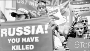  ??  ?? Syrian nationals living in Malaysia hold placards during a demonstrat­ion in solidarity with the inhabitant­s of the embattled Syrian city of Aleppo, outside the Russian Embassy in Kuala Lumpur. — AFP photo