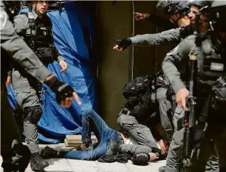  ?? Ammar Awad/Reuters ?? Policiais detêm palestino na Esplanada das Mesquitas, em Jerusalém