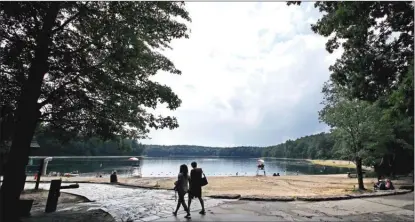  ?? The Associated Press (AP Photo/Michael Dwyer, File) ?? A couple walks along the shore of Walden Pond in Concord, Mass. Two centuries after Thoreau’s birth, people are still following in Henry David Thoreau’s footsteps to discover the little lake he immortaliz­ed, and its picturesqu­e and historic environs....