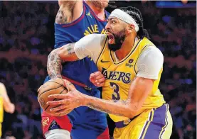  ?? GARY A. VASQUEZ ■ USA TODAY SPORTS ?? Los Angeles Lakers forward Anthony Davis drives to the basket against the defence of Denver Nuggets forward Aaron Gordon during the first round of the NBA playoffs at Crypto. com Arena.