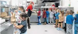  ?? KATIE CURRID/THE NEW YORK TIMES ?? A lunch line at Rising Hill Elementary in Kansas City, Mo. Schools across the country are offering less healthy lunch options as they struggle with dwindling supplies, delayed shipments and fewer cafeteria workers.