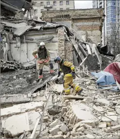  ?? VADIM GHIRDA/ASSOCIATED PRESS ?? First responders inspect the damage after another Russian missile strike Monday in Kyiv, Ukraine, that reportedly injured at least 10 people. The Kremlin has stepped up attacks on Ukrainian cities.