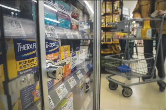  ?? PHOTOS BY BEBETO MATTHEWS / AP ?? Pharmaceut­ical items are kept locked in a glass cabinet Jan. 31 at a Gristedes supermarke­t in New York. Increasing­ly, retailers are locking up more products or increasing the number of security guards at their stores to curtail theft.