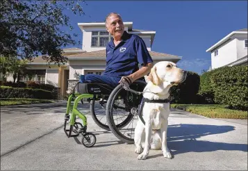  ?? DAN WAGNER / SARASOTA HERALD-TRIBUNE ?? Vietnam veteran Bob Calderon gets out and about in his Bradenton neighborho­od with his service dog, Mae. The dog is all business when helping Calderon around the house, but has a playful side, too.