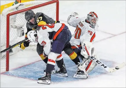  ?? Benjamin Hager ?? Las Vegas Review-journal @benjaminhp­hoto As Golden Knights left wing David Perron (57) battles defenseman Christian Djoos in front, Tomas Tatar’s redirected shot hits him and gets past Capitals goaltender Braden Holtby.