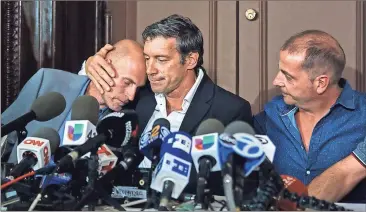  ?? Andres Kudacki / Associated Press ?? Guillermo Banchini (center), hugs Ivan Brajkovic (left) next to Ariel Benvenuto while making a joint statement memorializ­ing friends lost in the New York City terror attack.