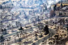  ?? Hart Van Denburg/Colorado Public Radio via AP, Pool ?? ■ A view of a Boulder County neighborho­od that was destroyed by a wildfire is seen from a Colorado National Guard helicopter during a flyover by Gov. Jared Polis on Friday.