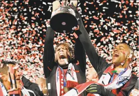  ?? Robert Edwards-KLC fotos / San Francisco Deltas ?? Deltas forward Tommy Heinemann (center) holds the NASL championsh­ip trophy alongside defender Reiner Ferreira at Kezar Stadium.