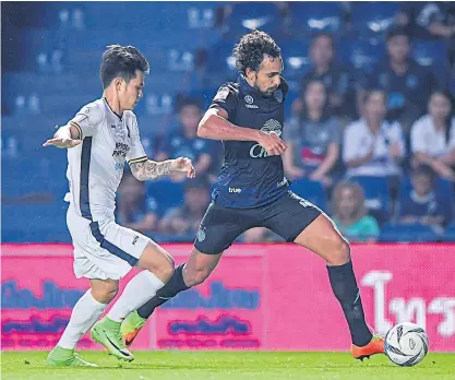  ??  ?? Buriram United’s Diogo Luis Santo, right, goes past a Pattaya United player.