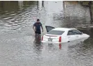  ?? HOUSTON CHRONICLE VIA AP ?? A man checks his vehicle in Houston after flooding from Tropical Storm Beta.