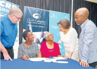  ??  ?? Launch of the CCRP Comprehens­ive Health Insurance Plan. Mr James Pawson (left), chairman of Gallagher Insurance Brokers; Mrs Jean Lowrie-Chin (second right), CCRP executive chairman; and Mr Willard Brown (right), executive vice president, Employee Benefits Division, Sagicor Life give informatio­n to interested members.