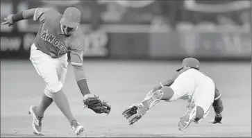  ??  ?? ANGELS SHORTSTOP
Erick Aybar, left, gets backup from Johnny Giavotella on Ryan Flaherty’s groundout.