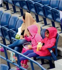  ?? Photo by Shihab ?? Spectators cover themselves up when Dubai Duty Free Tennis game was stopped because of drizzling. —