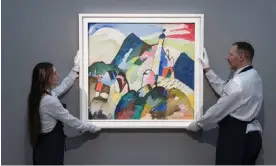  ?? Anadolu Agency/Getty Images ?? Art handlers display Kandinsky’s Murnau mit Kirche II at Sotheby’s in London. The painting is said to have heralded the Russian master’s move towards abstract art. Photograph: