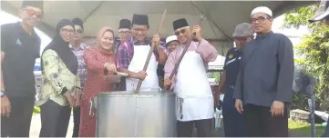  ??  ?? Dr Abdul Rahman (centre) and Abang Abdul Wahap on his left stir the porridge, as Siti Shorgayah (third left) adds some spices.