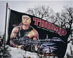  ?? RICK WILKING ?? Una bandera con Donald Trump caracteriz­ado al
estilo de Rambo