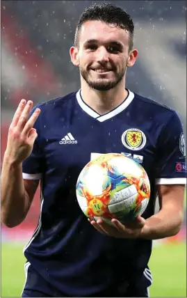  ??  ?? Scotland midfielder John McGinn with the match ball after his hat-trick