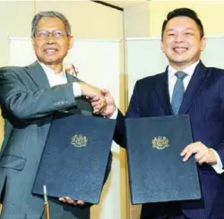  ??  ?? Leiking (right) and Mustapa during the official handover ceremony yesterday.