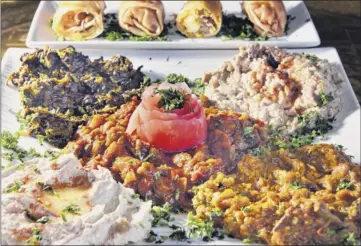  ?? Photos by John Carl D’annibale / Times Union ?? Moroccan dishes at Marrakesh in CliftonPar­k include, above, kefta kebab, which is ground beef marinated with spices and parsley, and, at left, Moroccan cigars, top, and a sampler of other appetizers.