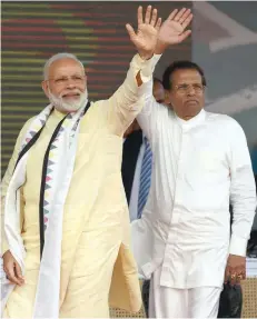  ?? — AFP ?? Indian Prime Minister Narendra Modi and Sri Lankan President Maithripal­a Sirisena wave to supporters after addressing a public rally in the tea-growing town of Norwood on Friday.