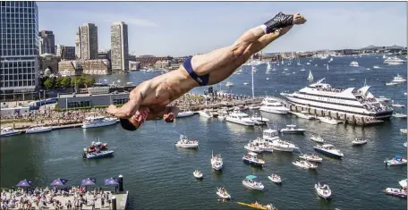  ?? DEAN TREML — HERALD FILE ?? MIGHT AS WELL JUMP: David Colturi of the United States dives from a platform atop the ICA Boston in 2013, when the Red Bull Cliff Diving World Series was last in Boston.