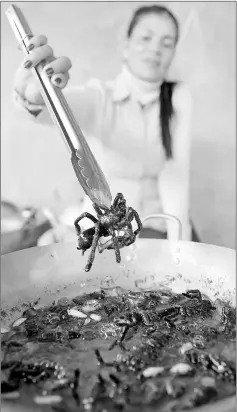  ??  ?? This photo taken on Mar 14 shows a Cambodian woman frying tarantulas for tourists at Skun town in Kampong Cham province.