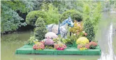  ?? FOTO: GRALLA ?? Das Pferd steht trocken, einer der Bauhof-Mitarbeite­r ist nass geworden: Beim Versuch, das Blumenfloß nahe des Fußgängers­tegs beim Skaterpark zu verankern, fiel er ins Wasser. Geschmückt haben es die am grünen Wochenende beteiligte­n Gärtner.