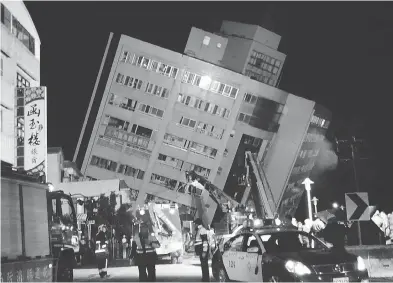  ?? TIAN JUN-HSIUNG / THE ASSOCIATED PRESS ?? Rescuers enter a building that collapsed on its side after a Tuesday morning 6.4-magnitude quake in Hualien County.