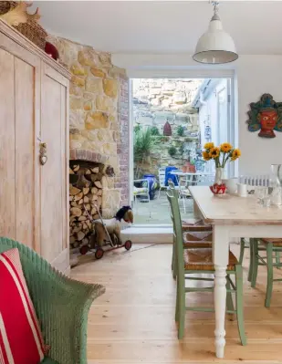  ??  ?? DINING AREAPart of the original Victorian sandstone wall has been exposed, echoing the outside wall and adding to the rustic coastal feel.The dining table is from Courthouse Street Traders and the dining chairs are a junk shop find. Helen bought the large cupboard at Heathfield Market and the enamel pendant light is from Shop