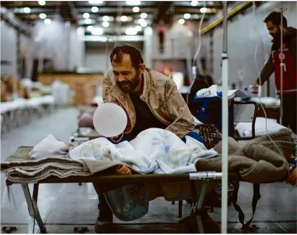  ?? Foto: Francisco Seco/ap/dpa ?? Ein Mann spielt mit seinem Kind in einem behelfsmäß­igen Krankenhau­s auf dem türkischen Kriegsschi­ff Bayraktar, das in einem Hafen nahe der südtürkisc­hen Stadt Iskenderun vor Anker liegt.