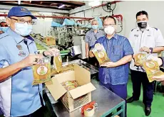  ??  ?? Nanta (centre) showing the subsidised cooking oil during a visit to a cooking oil processing factory in Taman Wahyu Kuala Lumpur yesterday. - Bernama photo