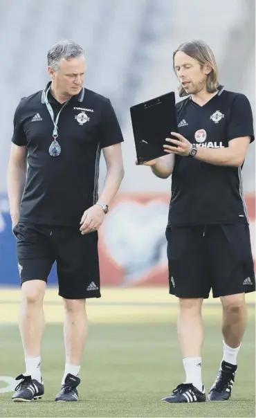  ??  ?? 0 Michael O’neill, left, and his assistant Austin Macphee during a Northern Ireland training session.