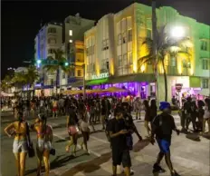  ?? D.A. Varela/Miami Herald via AP ?? Crowds walk Ocean Drive during spring break on Saturday in Miami Beach, Fla. Miami Beach officials imposed a curfew beginning Sunday night after two fatal shootings and rowdy crowds that police have had difficulty controllin­g.