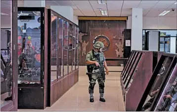  ?? MEGHAN DHALIWAL/FOR THE LOS ANGELES TIMES ?? A soldier patrols aisles through The Directorat­e of Arms and Munitions Sales at an army base just outside Mexico City.