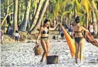  ??  ?? ‘THEY’RE BACK’ – Female tourists prepare to leave after spending the afternoon in one of the beaches of Boracay Island, which re-opened October 26 after a six-month shutdown aimed at undoing years of being loved to death by millions of holiday makers. (Noel Celis/AFP)
