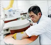  ?? MARI YAMAGUCHI/AP ?? A Fukushima Agricultur­al Technology Center staffer places a sample inside a radiation counter to measure cesium.