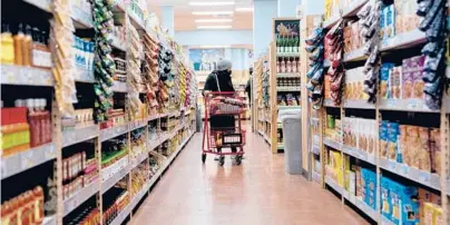  ?? STEFANI REYNOLDS/GETTY-AFP ?? A shopper walks through a grocery store March 13 in Washington, D.C. Inflation is driving grocery prices higher.