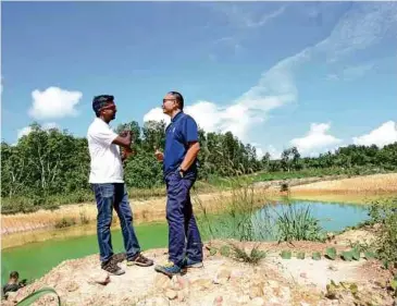  ??  ?? DR Anbarasu (kiri) dan Badrul meninjau kolam mengandung­i bakteria E Coli, racun serangga dan logam berat.