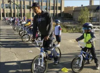  ?? MARIA DANILOVA — THE ASSOCIATED PRESS ?? Second-graders learn to ride bikes on the school yard from physical education teacher Terrance Chavis at Seaton Elementary School in Washington. At a time when elementary and high schools are all about getting students ready for college or jobs,...