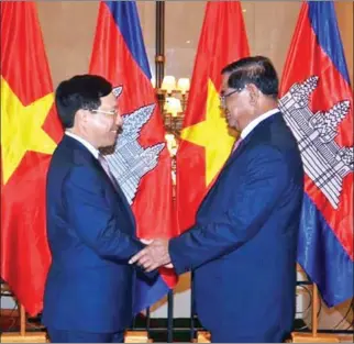  ??  ?? Cambodian Minister of Interior Sar Kheng shakes hands with Vietnamese Minister of Foreign Affairs Pham Binh Minh.