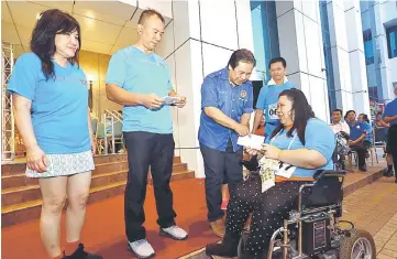  ??  ?? Dr Jerip presents a cheque to a representa­tive of Persatuan OKU Kuching (House of Joy), Ngu Nyok Ping.