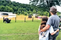  ?? TIMOTHY D. EASLEY/ASSOCIATED PRESS ?? Bonnie Combs, right, hugs her 10-year-old granddaugh­ter, Adelynn Bowling, Thursday as she watches her property become covered by the North Fork of the Kentucky River in Jackson, Ky.