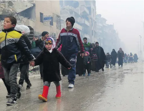  ?? GETTY IMAGES / AFP ?? Residents of Aleppo, Syria, flee violence in the Bustan al-Qasr neighbourh­ood on Tuesday. Regime fighters have retaken the area from rebels.