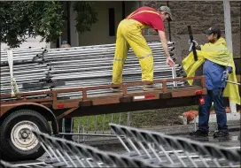  ?? RALPH BARRERA / AMERICAN-STATESMAN ?? Workers start to take down the railing and chairs at the UT Main Mall on May 23, 2015, as word came down that the commenceme­nt ceremony was being canceled for inclement weather. Although there is a 50 percent chance of rain for Saturday’s graduation,...