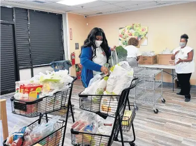  ?? GREATER CHICAGO FOOD DEPOSITORY PHOTOS ?? Volunteers Niya Scott, left, and Cynthias Medley stock shelves recently at the new Free N Deed food pantry in Dolton.