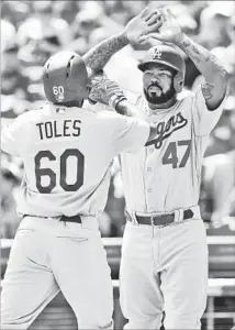  ?? Joe Robbins Getty Images ?? ANDREW TOLES is greeted by Dodgers teammate Howie Kendrick after hitting a two-run home run in the fifth inning.