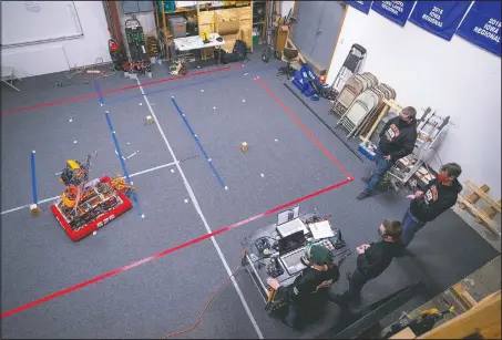  ??  ?? The FIRST Robotics Competitio­n Team 525 members watch as their robot runs an obstacle course through autonomous programmin­g.