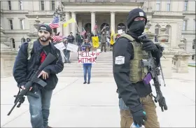  ?? ASSOCIATED PRESS FILE PHOTO ?? Protesters carry rifles near the steps of theMichiga­n State Capitol building in Lansing.