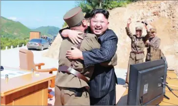  ?? KCNA VIA KNS/AFP ?? North Korean leader Kim Jong-un (centre) celebrates the successful test-fire of the interconti­nental ballistic missile Hwasong-14 at an undisclose­d location on Tuesday.